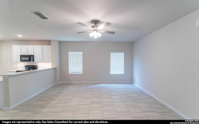 kitchen with black appliances, ceiling fan, and white cabinetry