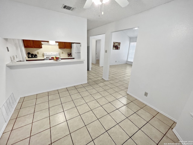 interior space with ceiling fan, a textured ceiling, and light tile patterned floors