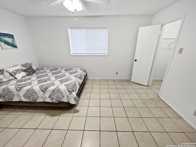 tiled bedroom with a textured ceiling and ceiling fan