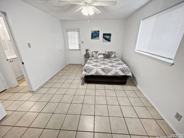 bedroom with ceiling fan, a textured ceiling, and light tile patterned flooring