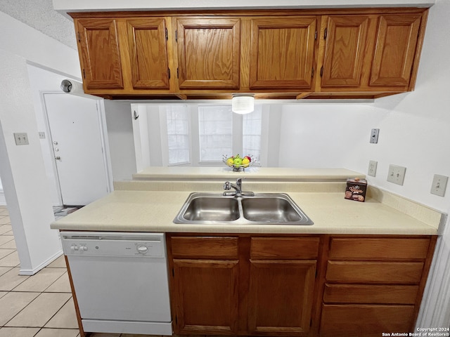 kitchen with white dishwasher, light tile patterned floors, and sink