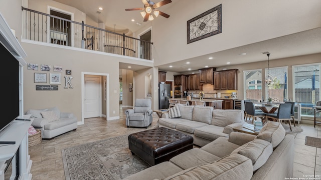 living room featuring ceiling fan and high vaulted ceiling