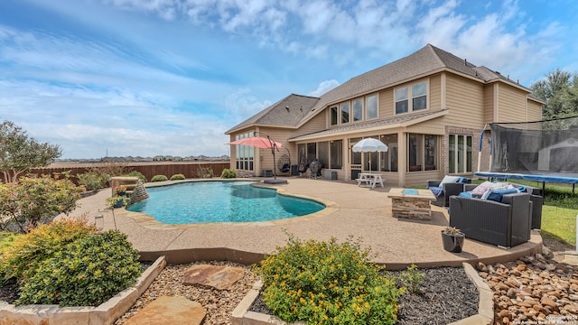 view of swimming pool featuring a trampoline, an outdoor living space with a fire pit, and a patio area