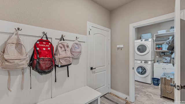 washroom featuring stacked washer / drying machine