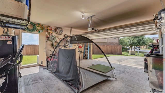 garage with a garage door opener and black refrigerator