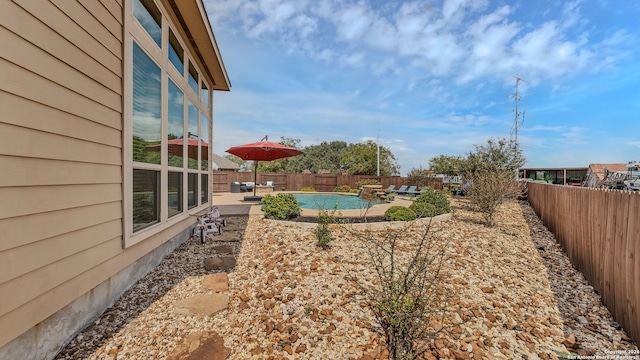 view of yard featuring a fenced in pool and a patio