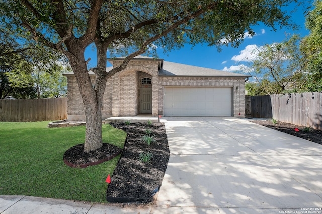 ranch-style home with a front lawn and a garage