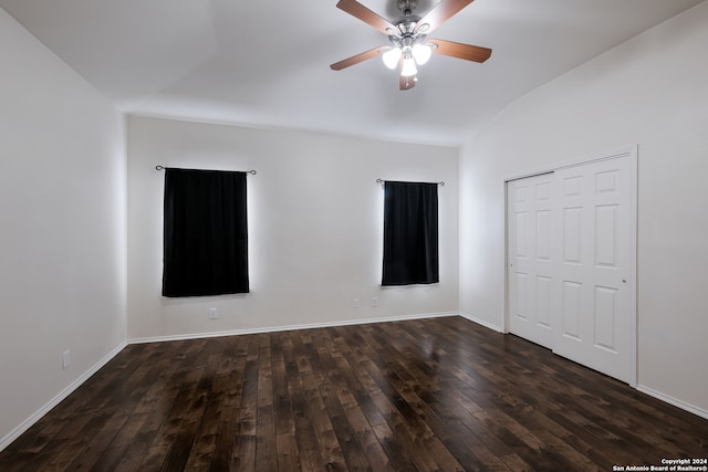 empty room with lofted ceiling, ceiling fan, and dark hardwood / wood-style floors