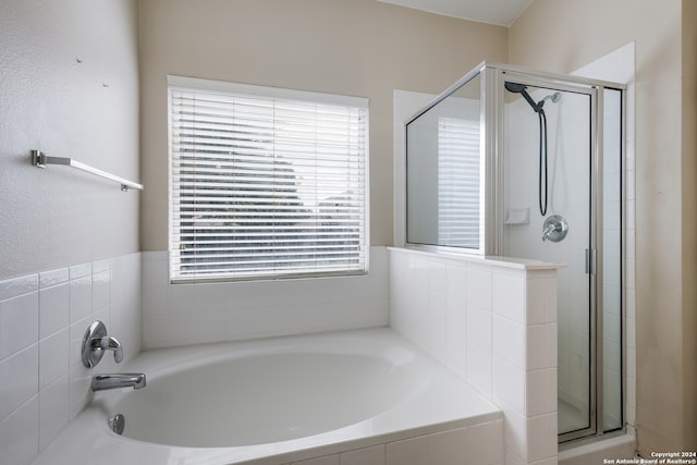 bathroom featuring plus walk in shower and plenty of natural light