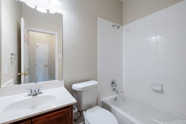 full bathroom featuring tiled shower / bath, vanity, and toilet