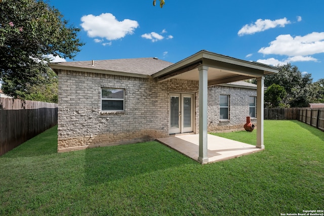 rear view of property with a yard and a patio