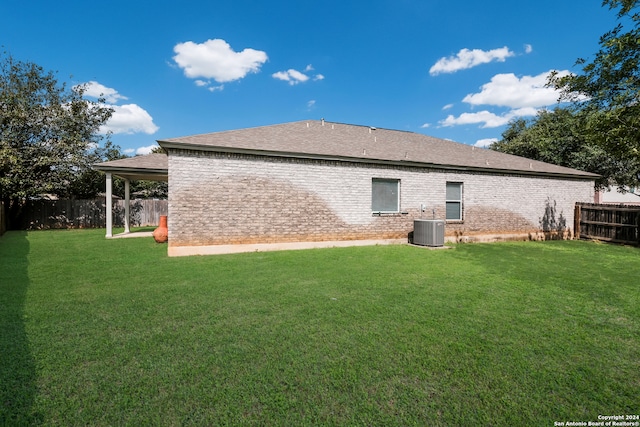 rear view of property with a lawn and cooling unit