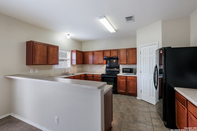 kitchen with light tile patterned flooring, kitchen peninsula, black appliances, range hood, and sink