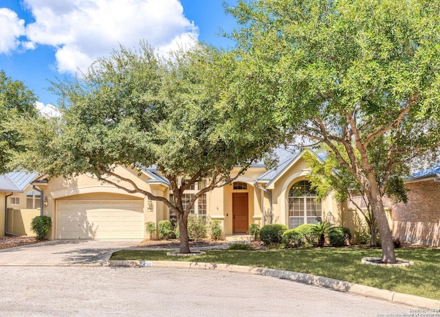 view of front of house with an attached garage, concrete driveway, stucco siding, and a front lawn