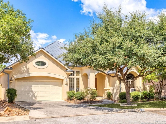mediterranean / spanish-style house with stucco siding, a garage, and concrete driveway