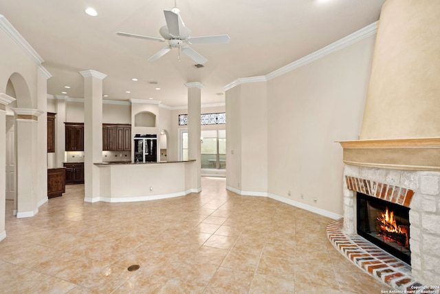 unfurnished living room with ceiling fan, ornate columns, and ornamental molding