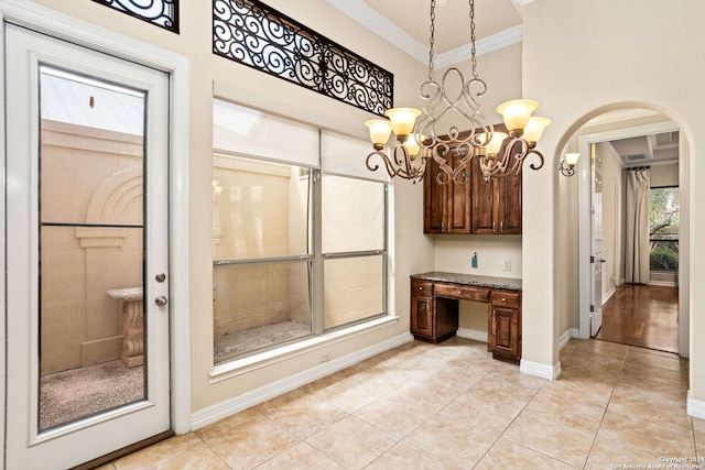 interior space featuring a healthy amount of sunlight, light tile patterned floors, crown molding, and a chandelier