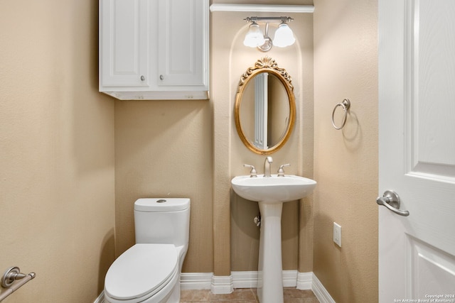 bathroom with an inviting chandelier, toilet, and tile patterned floors