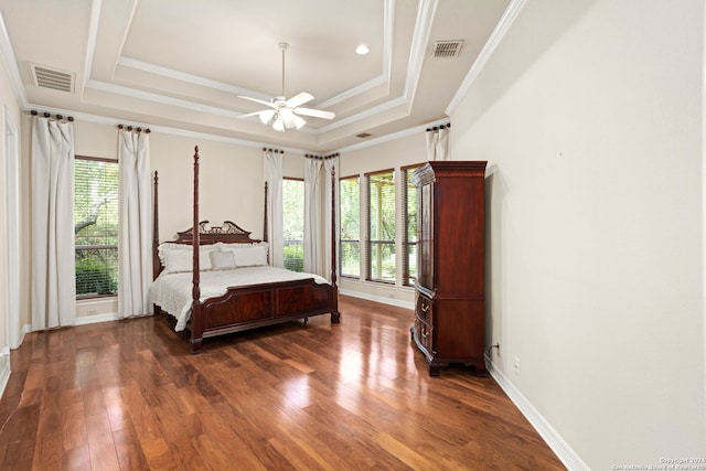 bedroom featuring ornamental molding, a tray ceiling, ceiling fan, and dark hardwood / wood-style floors