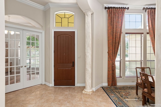 tiled foyer featuring french doors, ornamental molding, and decorative columns