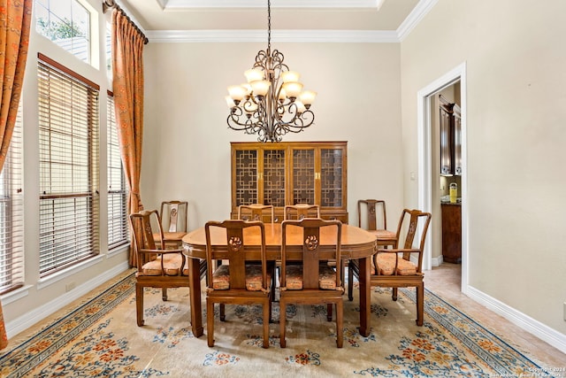 dining room with a high ceiling, a notable chandelier, baseboards, and crown molding