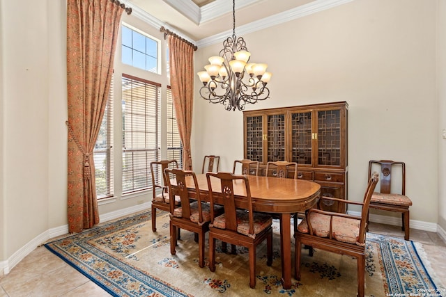 dining space with a high ceiling, a notable chandelier, ornamental molding, and baseboards