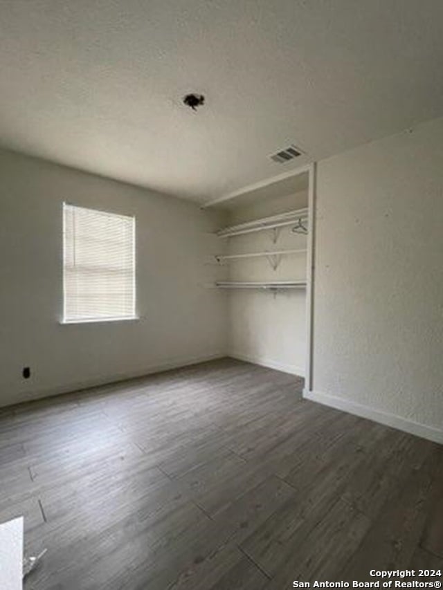 unfurnished bedroom featuring dark hardwood / wood-style floors and a closet