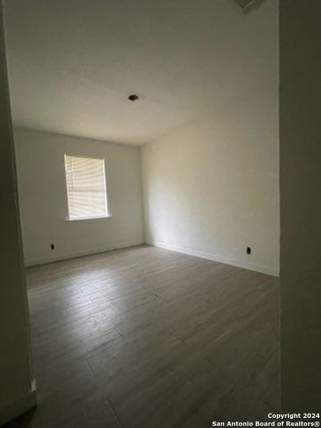 spare room with dark hardwood / wood-style flooring