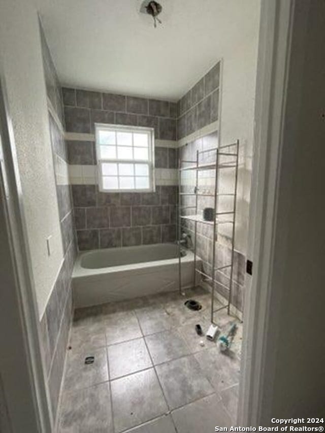 bathroom with tiled shower / bath combo and tile patterned floors