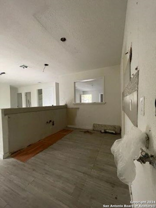 unfurnished room with hardwood / wood-style flooring and a textured ceiling