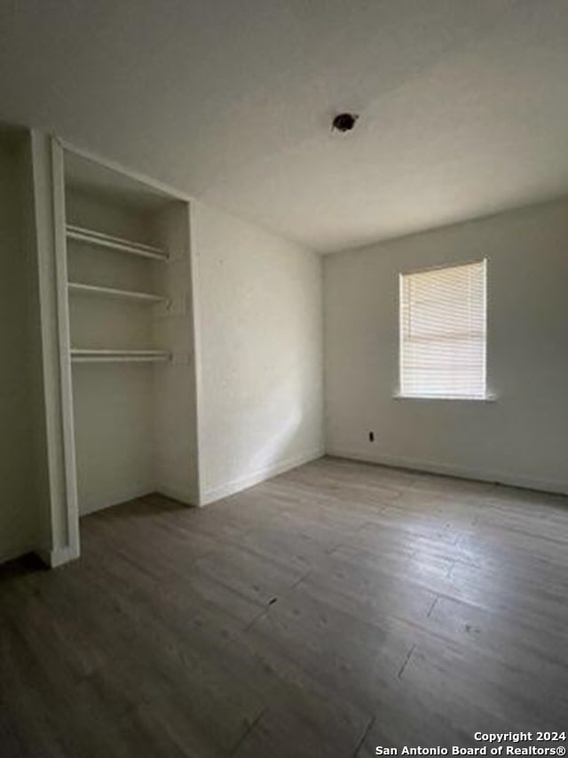 unfurnished bedroom featuring hardwood / wood-style floors and a closet