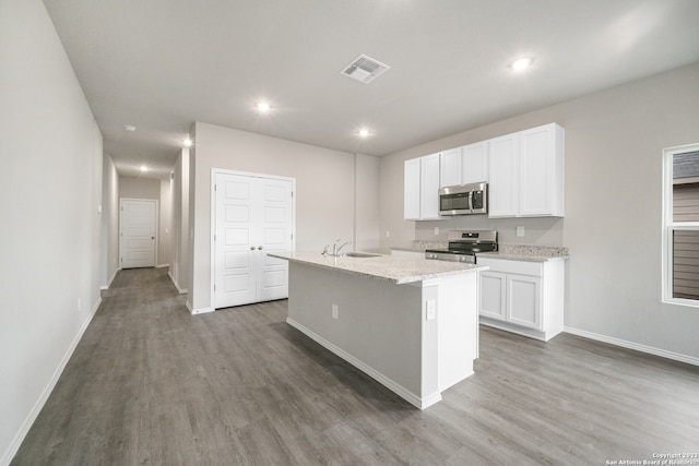 kitchen with white cabinets, a kitchen island with sink, appliances with stainless steel finishes, and dark wood-type flooring