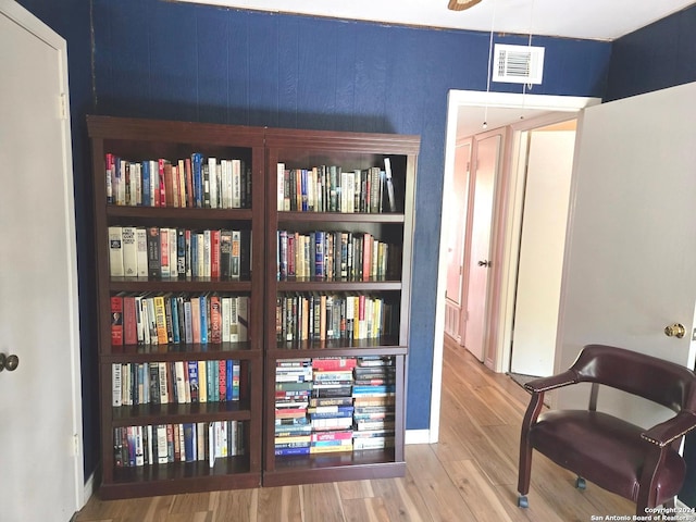 living area featuring wooden walls and hardwood / wood-style floors