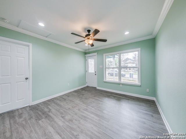 spare room featuring crown molding, light hardwood / wood-style floors, and ceiling fan