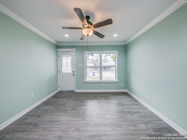 empty room with ceiling fan, ornamental molding, and dark hardwood / wood-style flooring