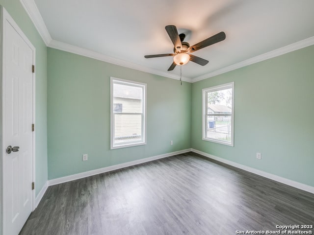 unfurnished room with ceiling fan, dark wood-type flooring, and crown molding