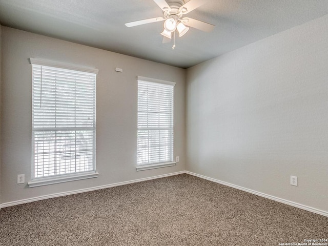 carpeted spare room featuring ceiling fan and a textured ceiling