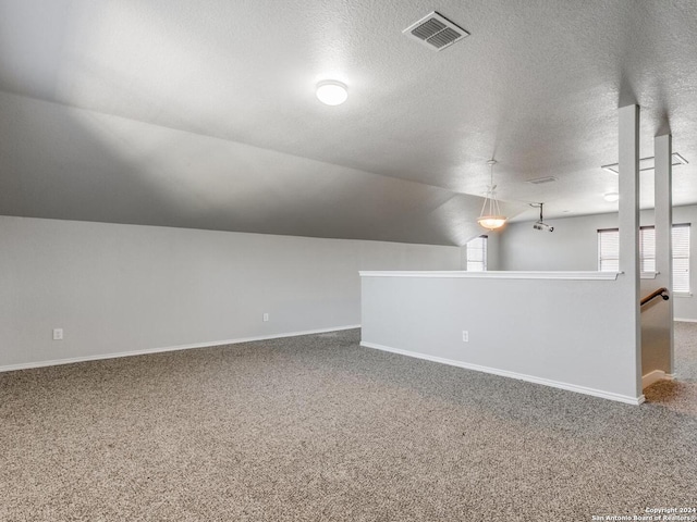 bonus room with carpet flooring, a textured ceiling, and vaulted ceiling