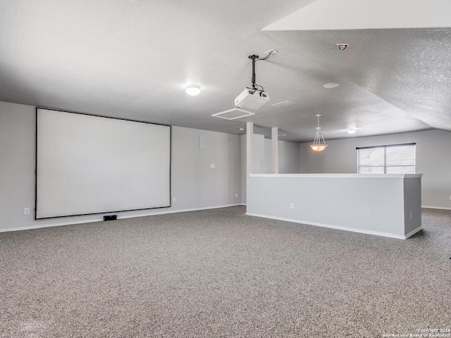 carpeted home theater with a textured ceiling and lofted ceiling