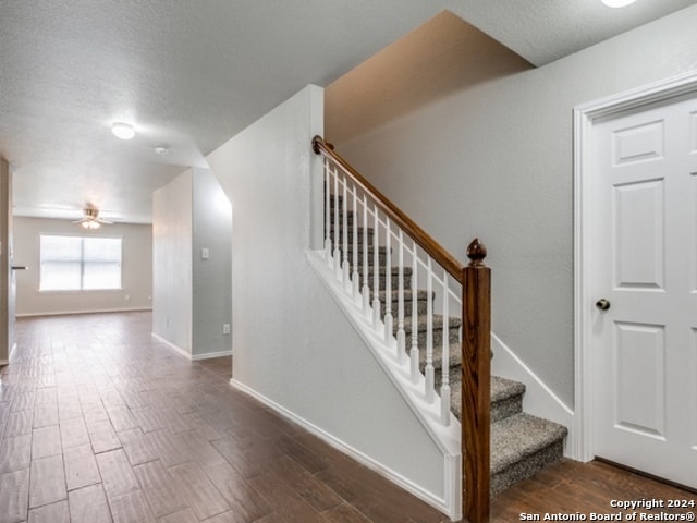 stairs with a textured ceiling and hardwood / wood-style flooring