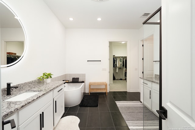 bathroom featuring a bathing tub, vanity, radiator, and tile patterned floors