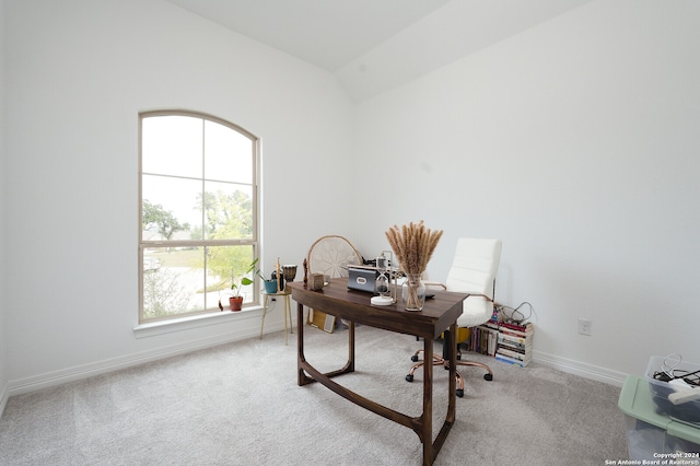 office with lofted ceiling and light carpet