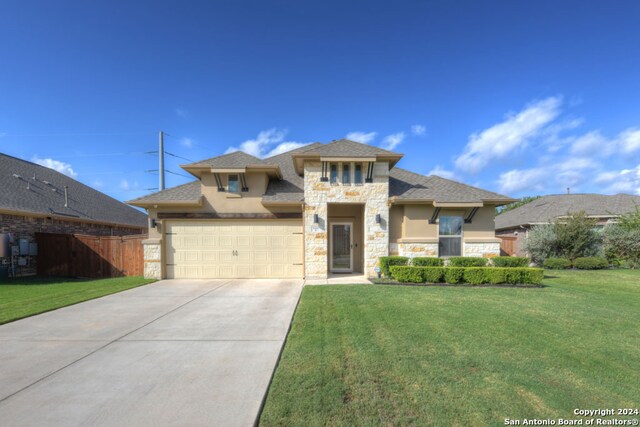 view of front of property featuring a garage and a front lawn