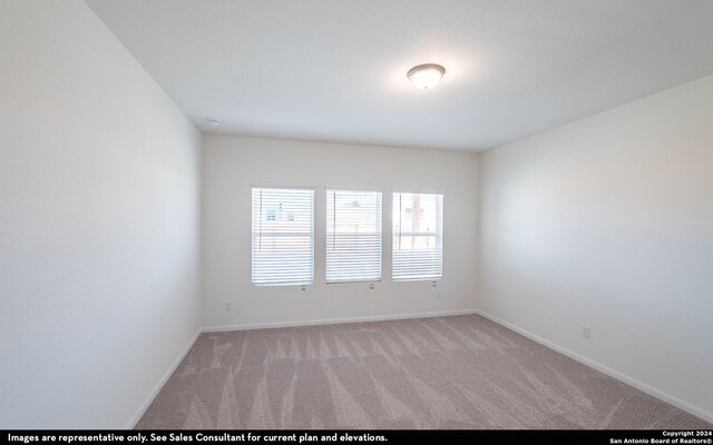 spare room featuring light carpet