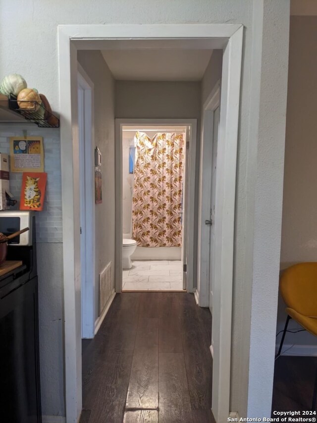 corridor featuring dark wood-type flooring