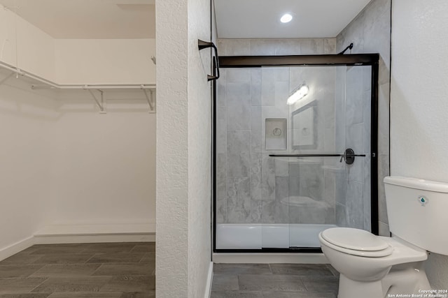 bathroom with walk in shower, hardwood / wood-style floors, and toilet