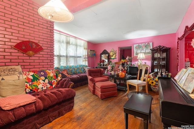 living room with wood-type flooring and brick wall