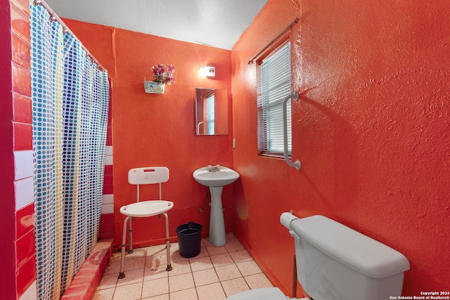 bathroom featuring tile patterned flooring, sink, curtained shower, and toilet