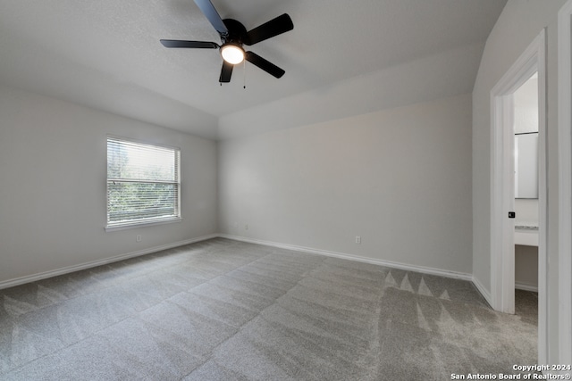 unfurnished room with ceiling fan, lofted ceiling, and light carpet