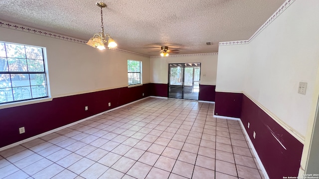 empty room with ornamental molding, a textured ceiling, ceiling fan with notable chandelier, and light tile patterned floors